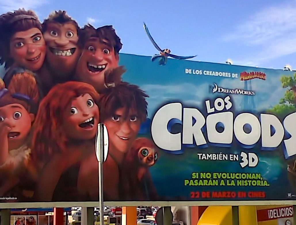 Valla corpórea publicitaria de gran formato con impresión de alta calidad, utilizada para la promoción de la película 'Los Croods' en un soporte publicitario exterior.