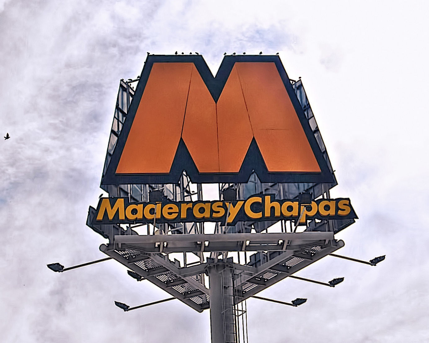 Monoposte publicitario corpóreo de gran formato con letras y logotipo en relieve, diseñado para destacar la identidad de Maderas y Chapas con iluminación exterior.