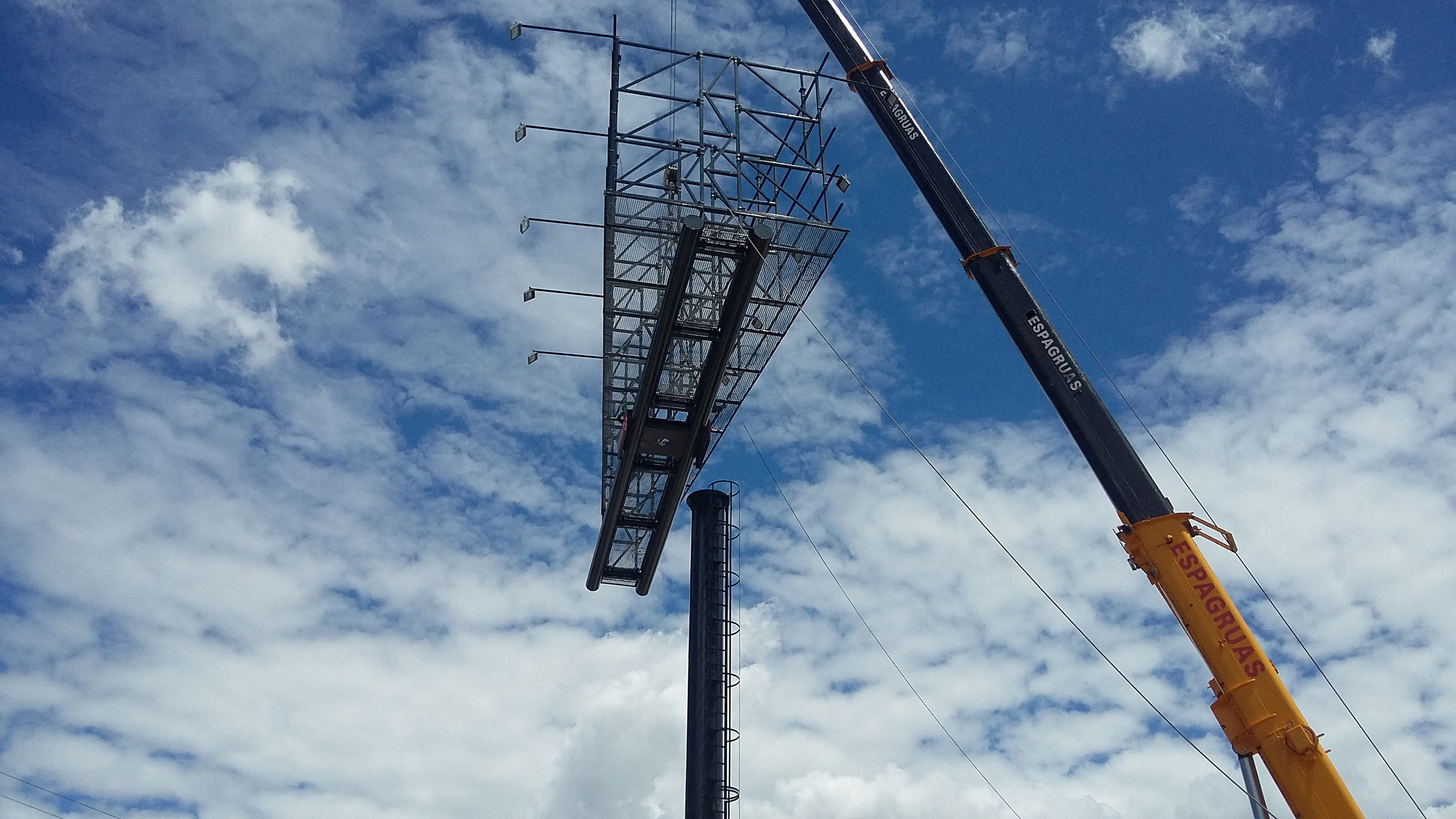 Montaje de una valla publicitaria de gran formato mediante grúa, asegurando una instalación precisa y segura en altura.
