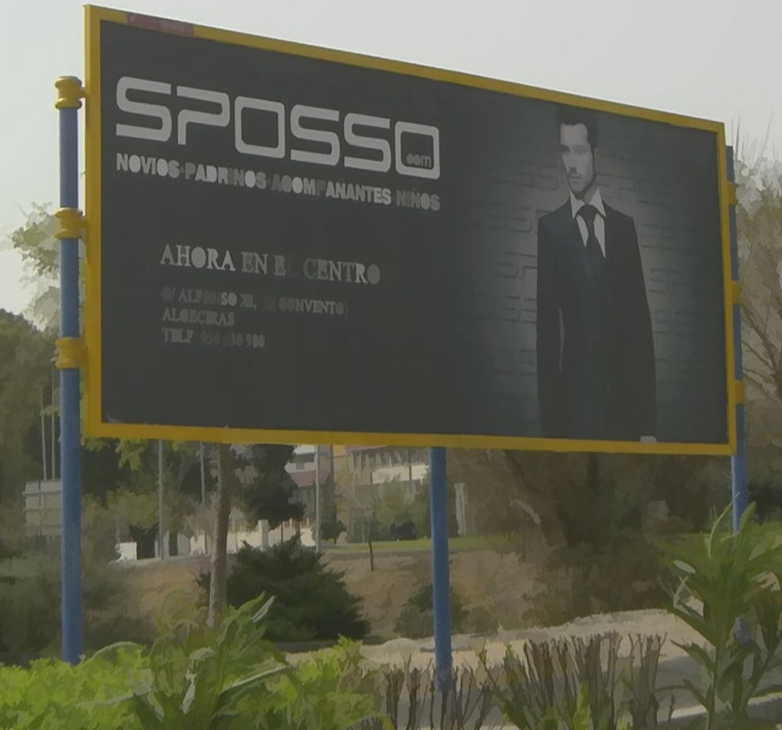 Valla publicitaria de gran formato con estructura metálica y diseño en relieve, promocionando la marca Sposso en una ubicación estratégica.